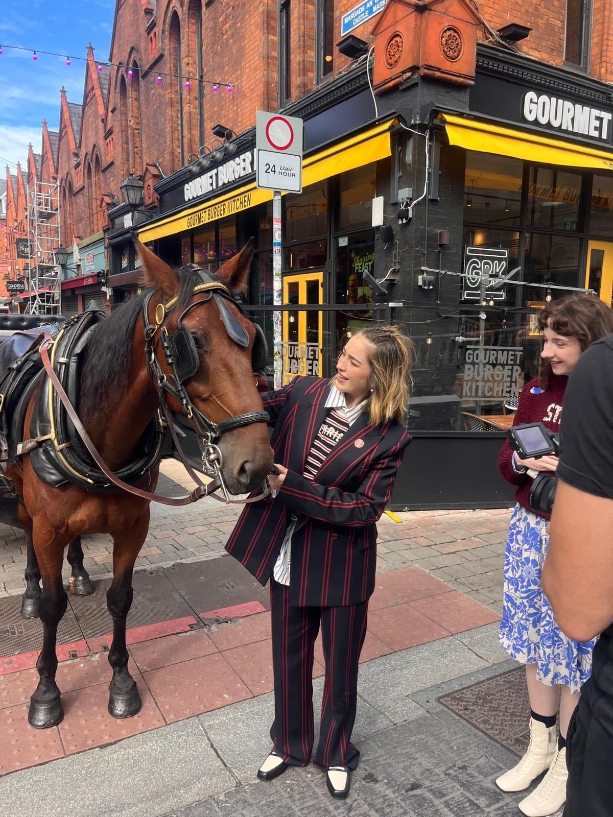 A camera operator filming one of the horses on a Dublin street