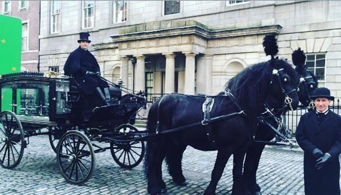 Period hearses and black horses on a cobbled Dublin street during filming